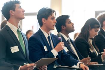 Business students in suits, looking attentively.
